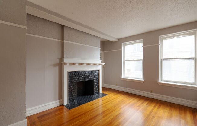 the living room of an empty house with a fireplace