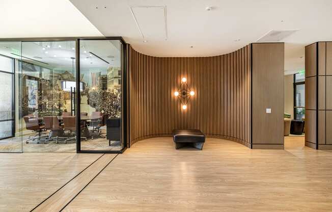 a large lobby with a wooden wall and a black chair