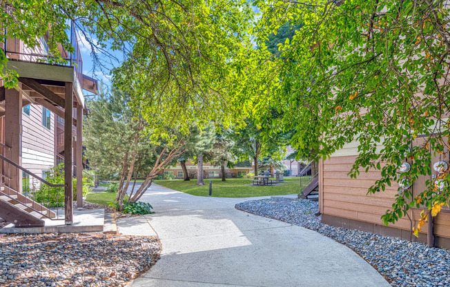 a walkway leading to a house with trees and a sidewalk