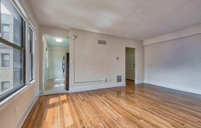 an empty living room with wood flooring and a large window