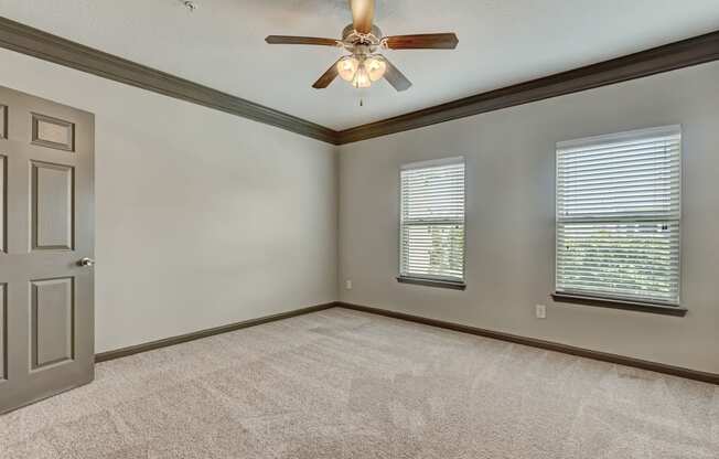 Spacious Carpeted Bedroom With Ceiling Fan & Light