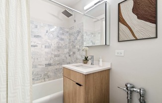 a small bathroom with a sink and a shower and a mirror