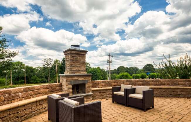 the patio has a stone fireplace and furniture on it