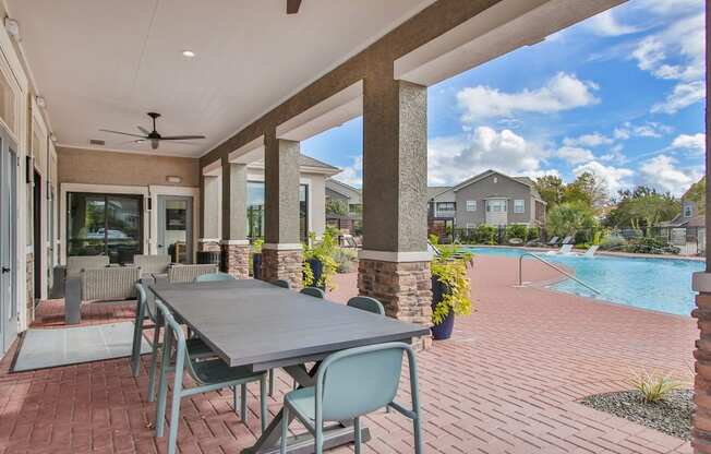 an outdoor patio with a table and chairs and a swimming pool at Sladestone Shadow Creek, Pearland, TX