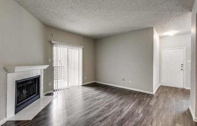 A room with a fireplace and wood flooring.
