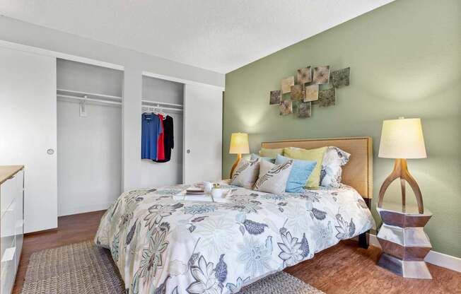 A bedroom with a large bed and a lamp on a side table.