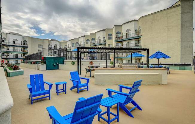 A patio with blue chairs and tables.