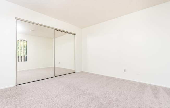 Bedroom with large mirror and closet at Woodbend, Alta Loma, California