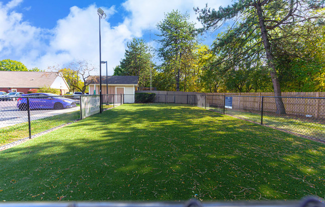 a fenced in backyard with a lawn and a fence