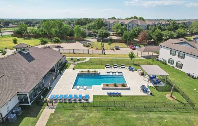 an aerial view of a swimming pool in front of a house