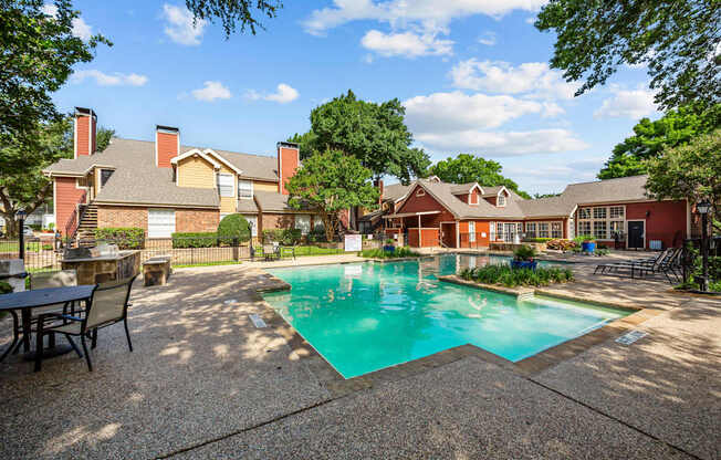 A pool surrounded by a patio and trees.