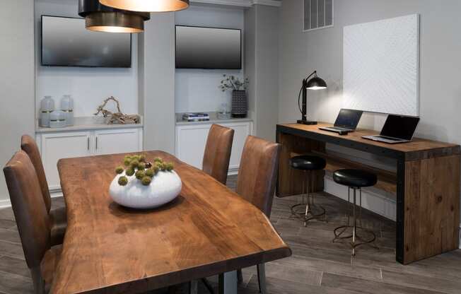 a dining room with a table and chairs and a desk with a laptop