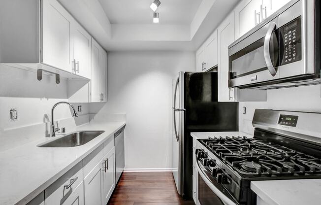 a kitchen with white cabinets and stainless steel appliances