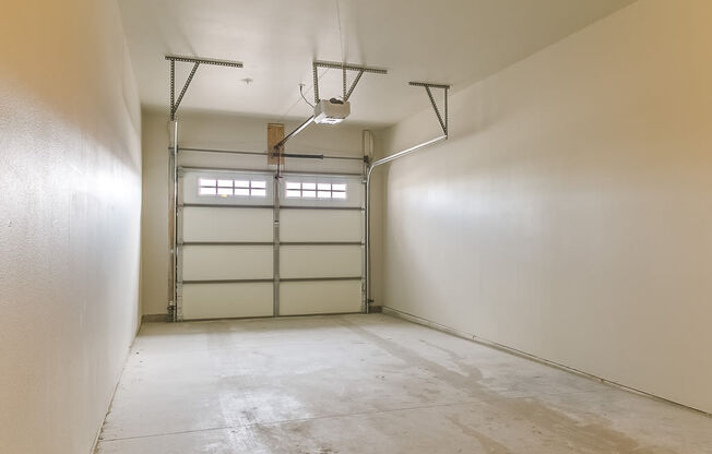 an empty room with white walls and a garage door