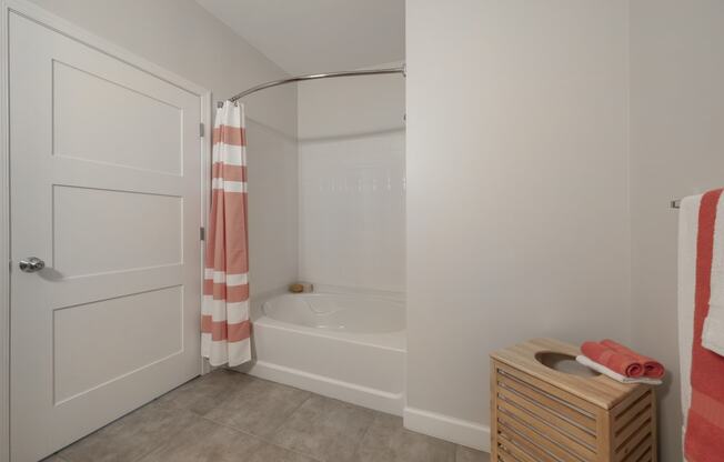a bathroom with a tub and a shower and a dresser