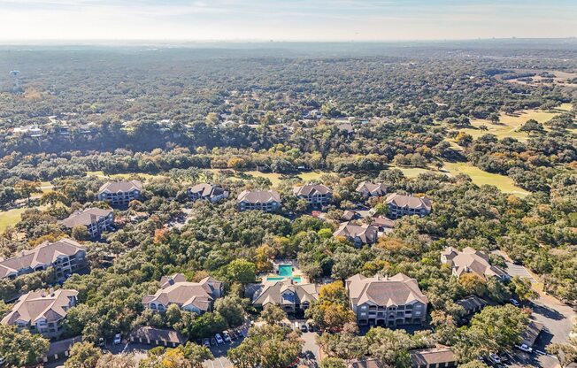 A bird's eye view of a residential area with houses surrounded by trees.