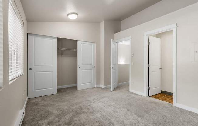 A room with white doors and a carpeted floor.