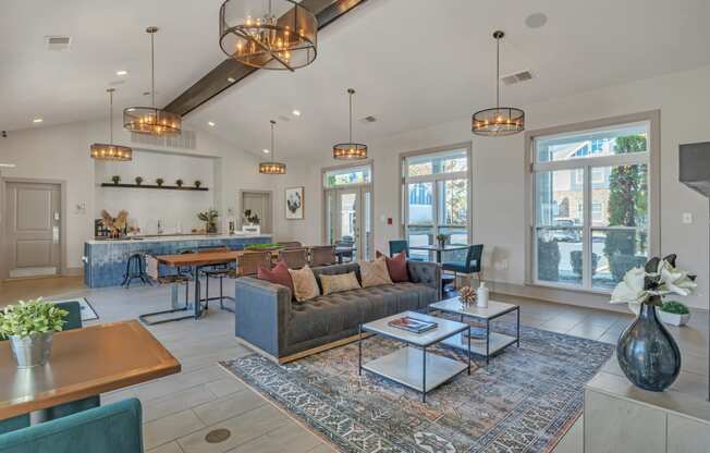 a living room with couches and tables and a kitchen