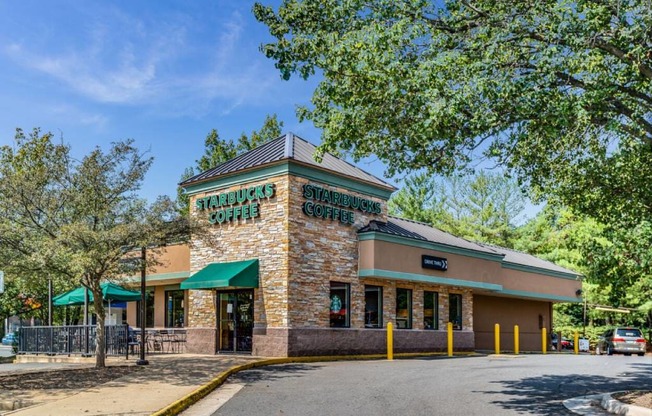 the facade of a restaurant with trees and a road
