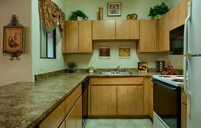 Apartments for Rent in Surprise, AZ - Radiate Kitchen with black and white appliances, and wood cabinets