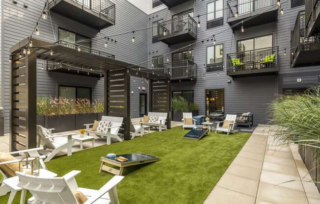 a courtyard with chairs and tables and grass