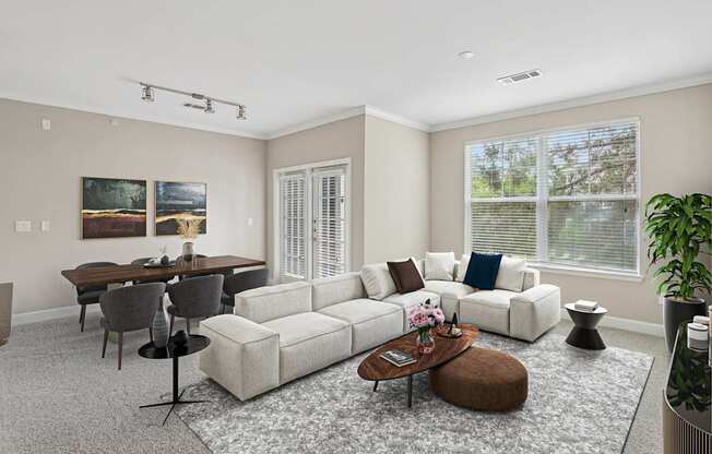 A living room with a white couch, a coffee table, and a dining table.