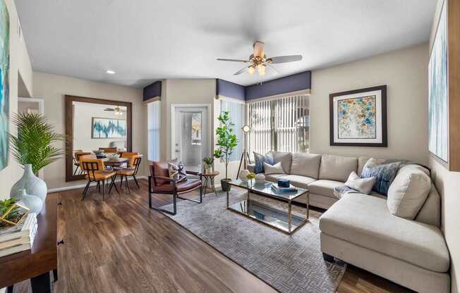 A living room with a white couch, a coffee table, and a ceiling fan.