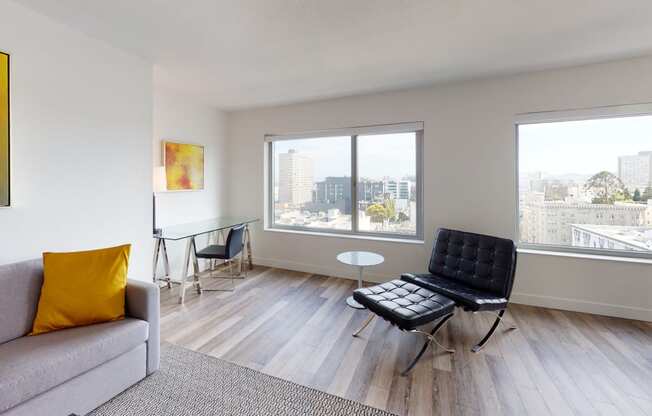 a living room with a couch chair and table with a view of the city