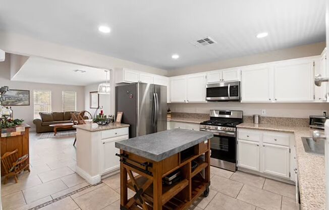 House has open kitchen with crisp white cabinetry with large backyard.