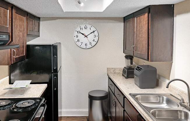 a kitchen with a sink and a clock on the wall