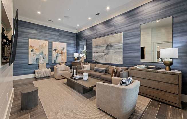 A modern living room with a grey wall and a large painting.