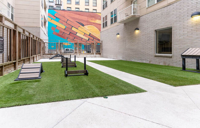 a courtyard with benches and a mural on the side of a building