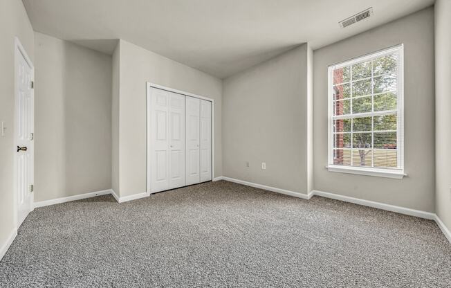 an empty room with carpet and a window