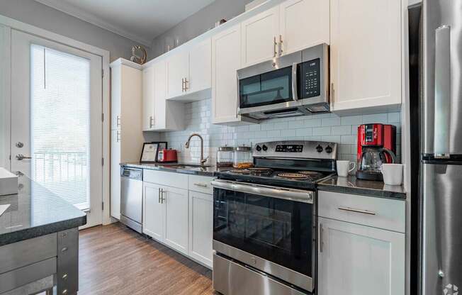 A kitchen with white cabinets and stainless steel appliances.at Century Baxter Avenue, Louisville, 40204