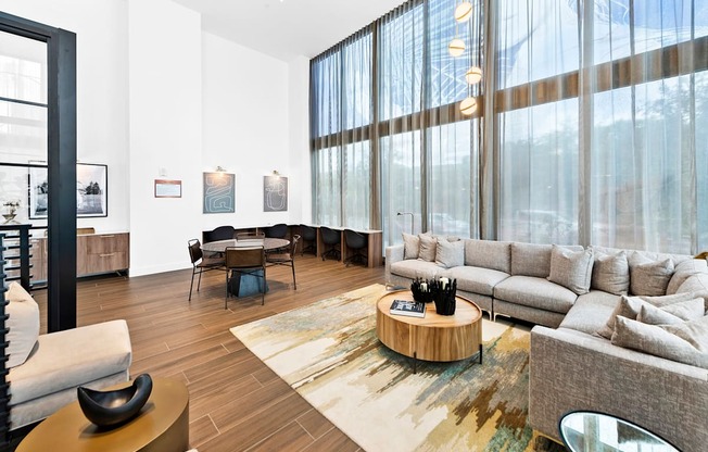 a living room with white walls and large windows