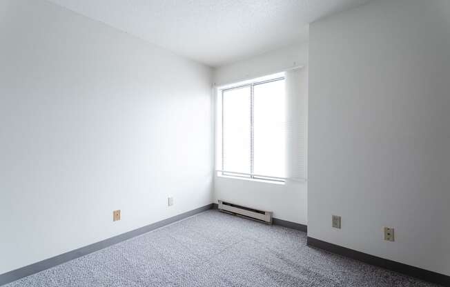 A room with a window and a radiator on the floor. at Bristol Ridge, Urbandale, Iowa