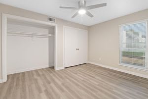 an empty room with a ceiling fan and a window