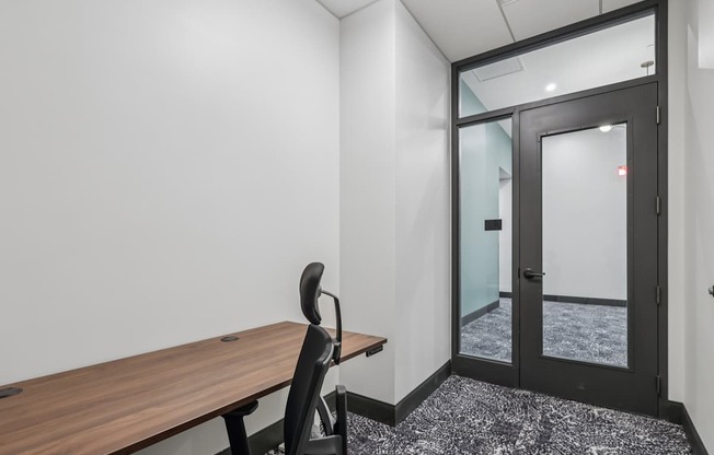 A room with a wooden table and a black chair.