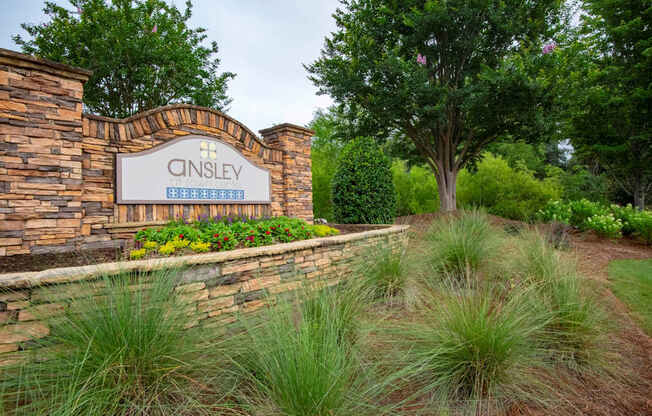 A stone wall with a sign that says Cinsley.