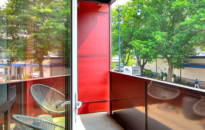 A red wall with a chair in front of it. at Ravello Apartments, Redmond, WA