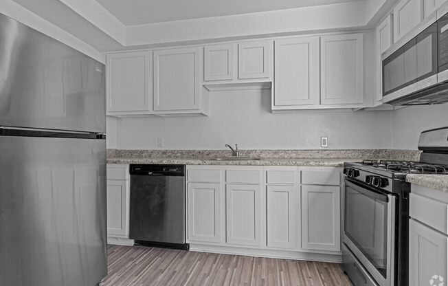 a kitchen with white cabinets and stainless steel appliances