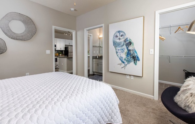 a bedroom with a white bed and a painting of an owl at Ansley at Town Center in Evans GA
