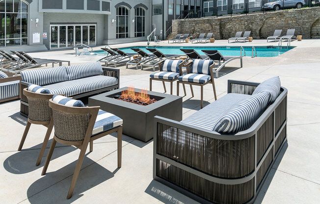 a pool with lounge chairs and a fire pit at The Heights Apartments, Ohio, 45220