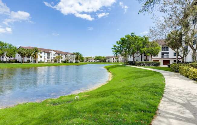 a pathway around a lake with houses on the side of it