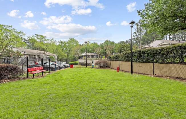 a grassy area with a bench and lampposts