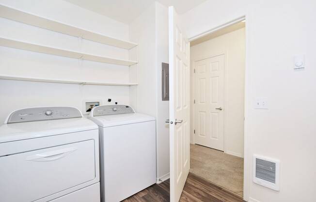 a white washer and dryer in a room with a door