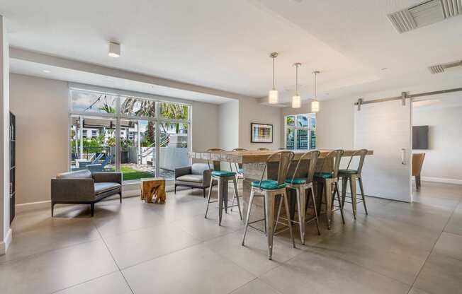 the living room and dining area of a house with a bar and chairs