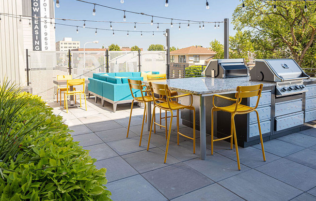 a patio with a table and chairs and a grill at The Landing at 1001 NP, Fargo, ND 58102