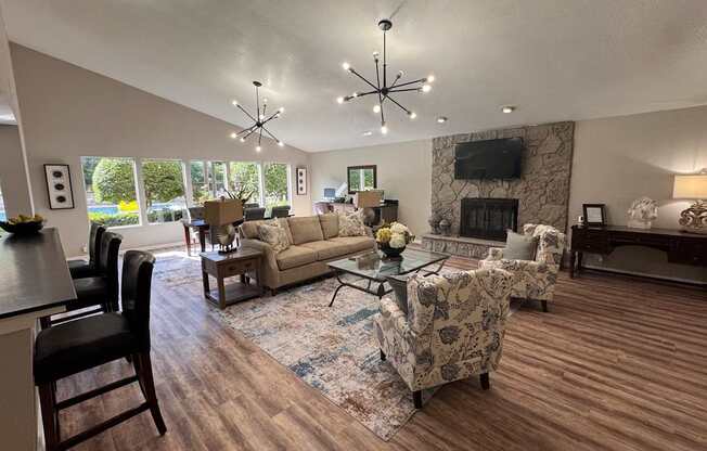A living room with a stone fireplace and a large window.