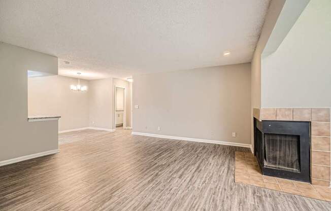 A room with a fireplace and wood flooring.